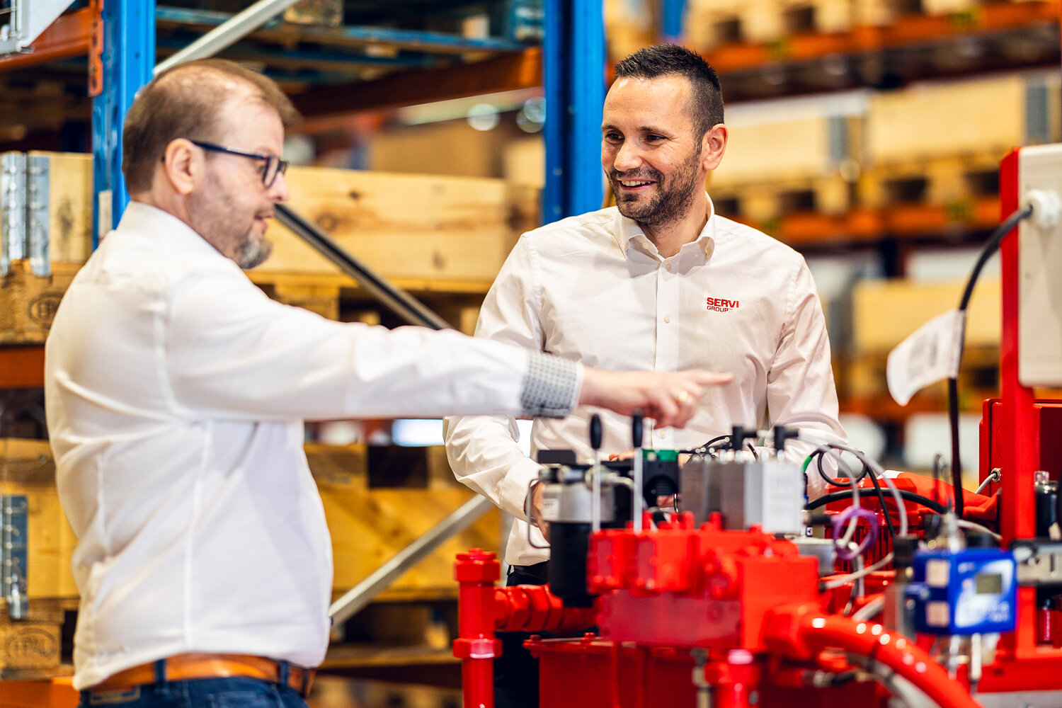 Bilde av to selgere som inspiserer et hydraulikkaggregat