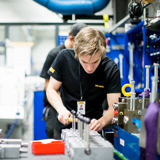 Image of an employee working with a valve, with tools and equipment nearby