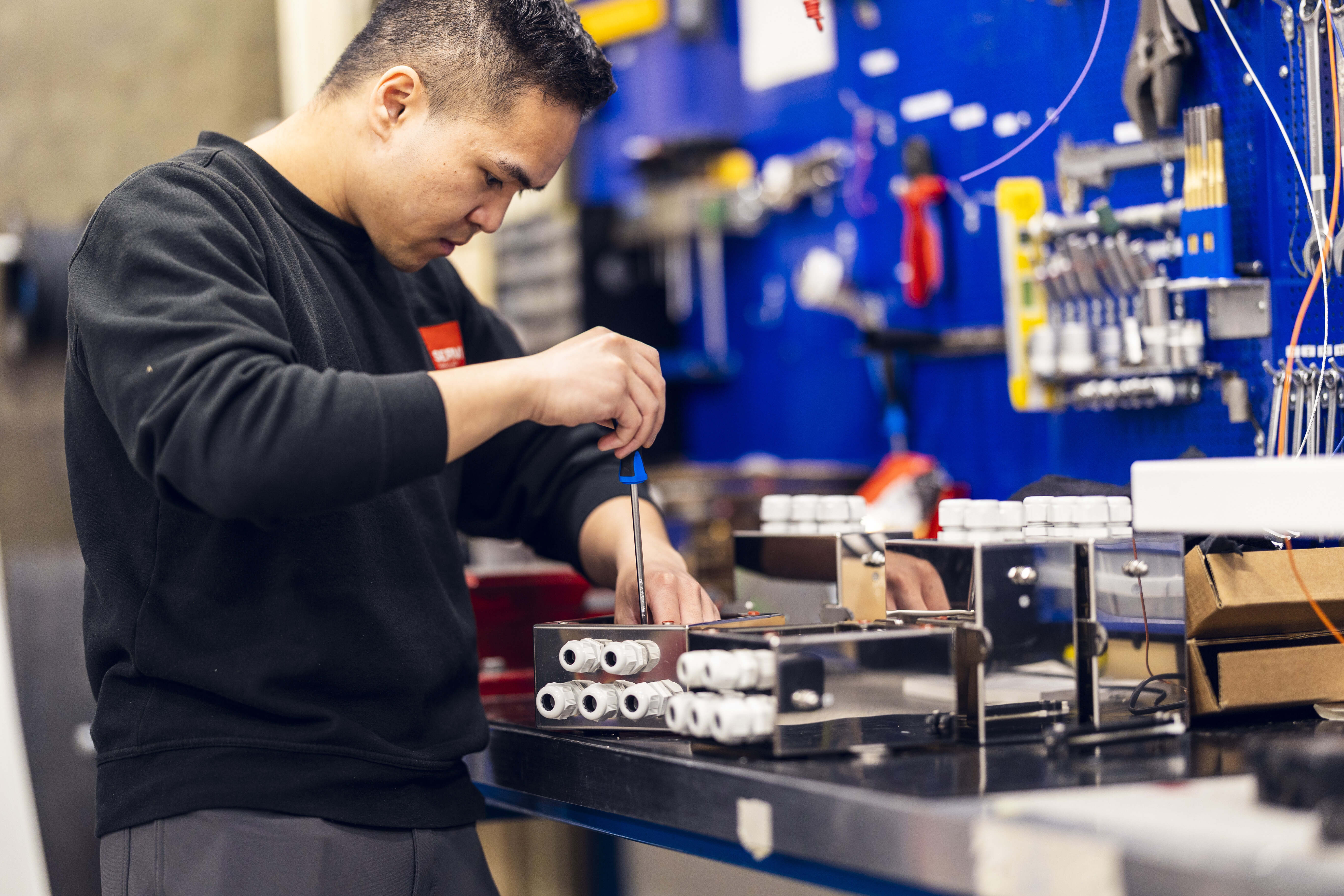 A technician from Servi is seen installing and fine-tuning an electrical and control system in an industrial setting, demonstrating precision and expertise. | © Øyvind Welle