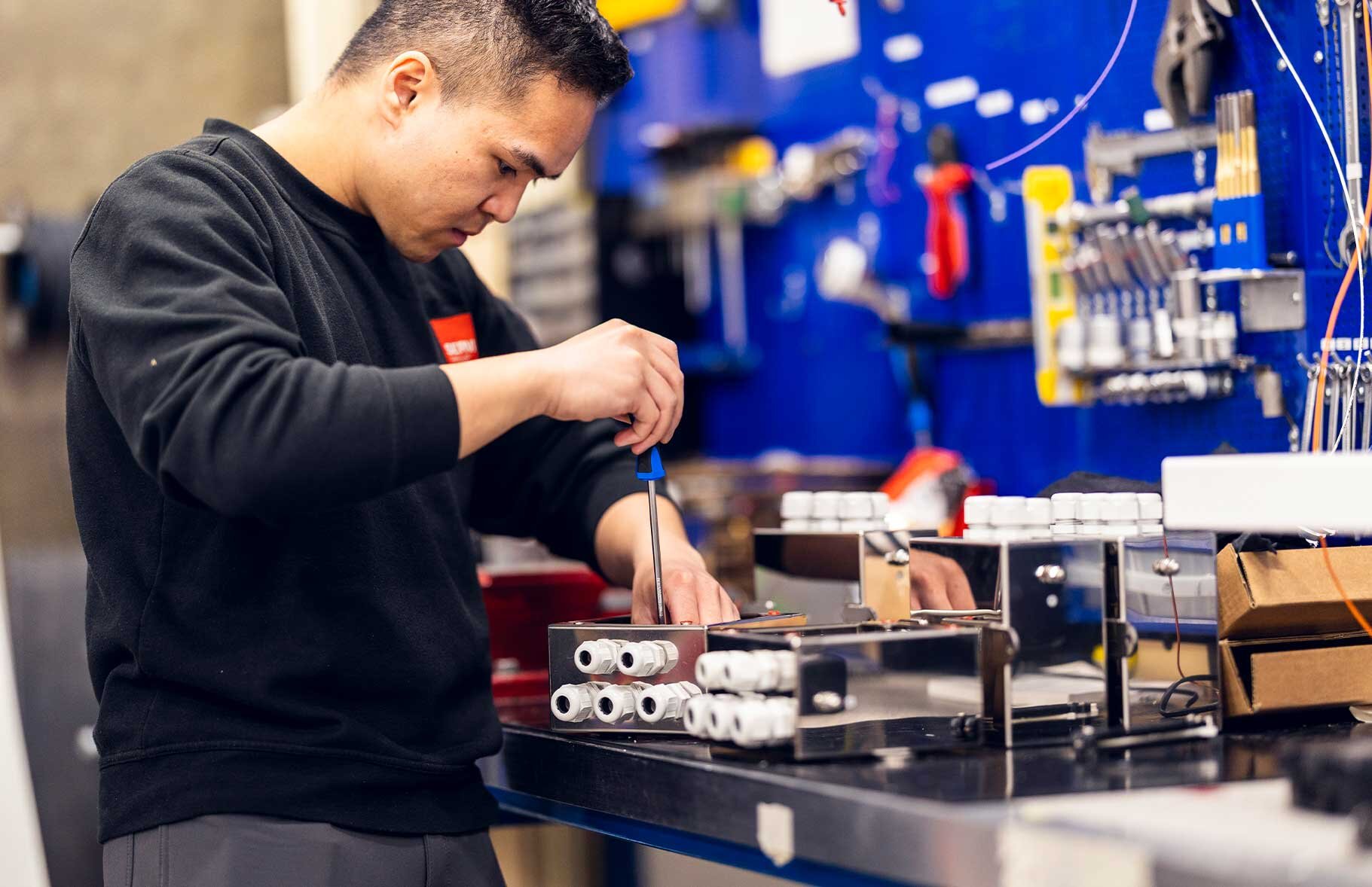 A technician from Servi is seen installing and fine-tuning an electrical and control system in an industrial setting, demonstrating precision and expertise. | © Øyvind Welle