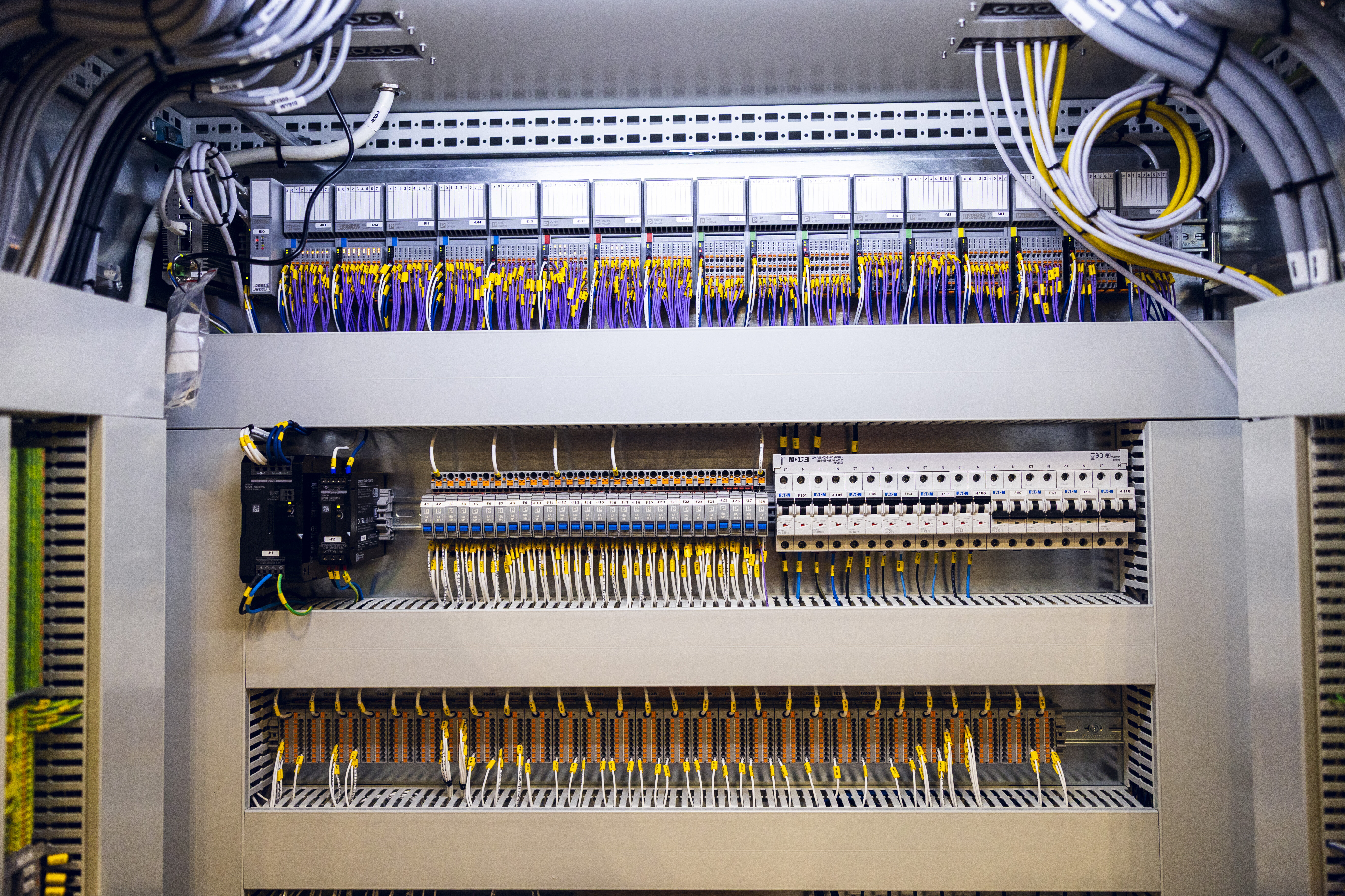 Innsiden av et større elektroskap fylt med elektriske komponenter, ledninger og koblinger | © Øyvind Welle