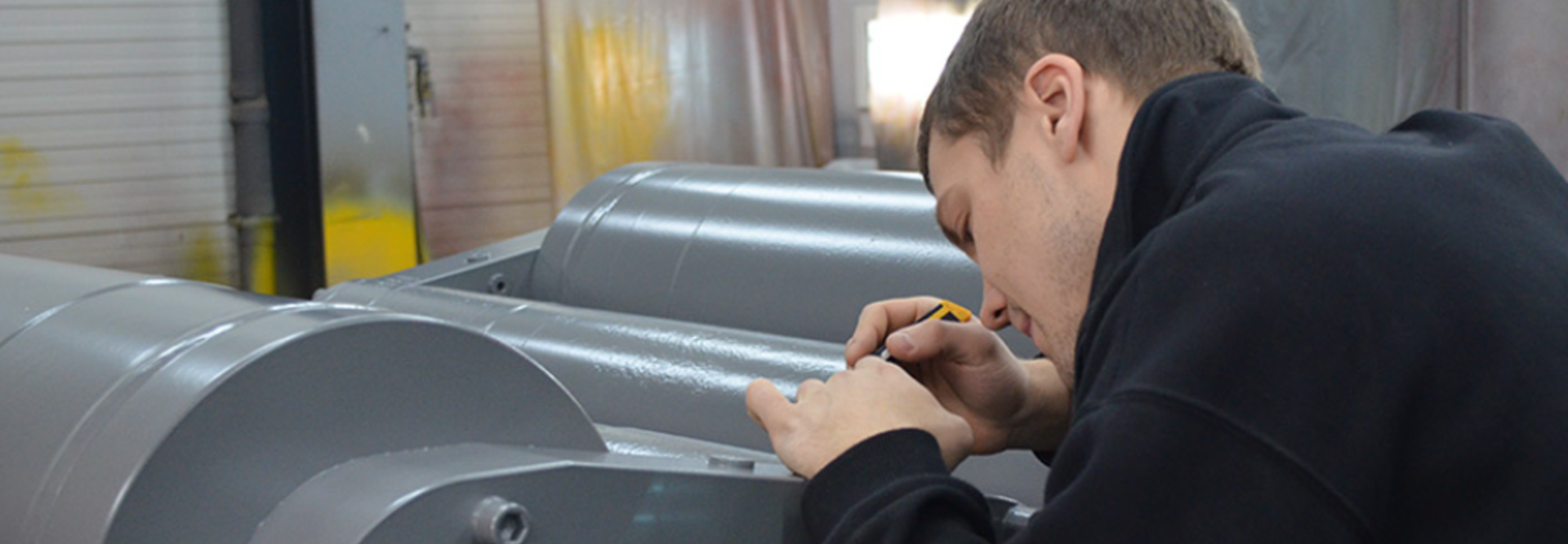 Person does detail work on a cylinder after coating