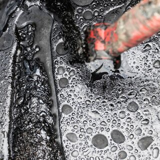 Nærbilde av bitumen som viser detaljene i asfaltmaterialet.