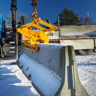  Et bilde av en autovern løfteteng fra BSV som løfter en stor betongblokk sett fra siden. Det er snø på bakken og rundt byggeplassen, og betongblokken henger i luften.