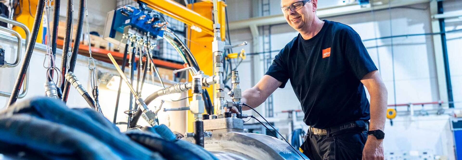 Image of a production worker at the cylinder factory in Rissa standing over a cylinder ready for pressure testing.