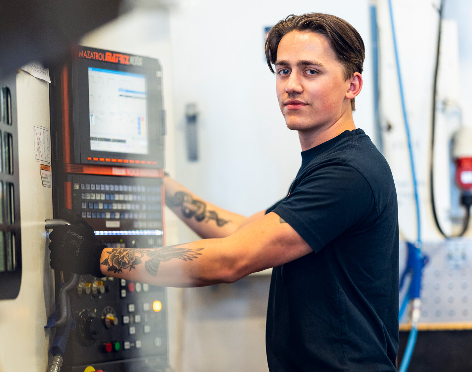production worker standing in front a machine at the cylinder factory