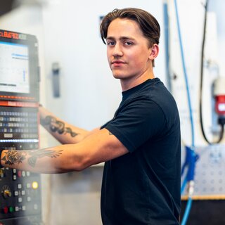 En person som arbeider på en maskin på sylinderfabrikken i Rissa