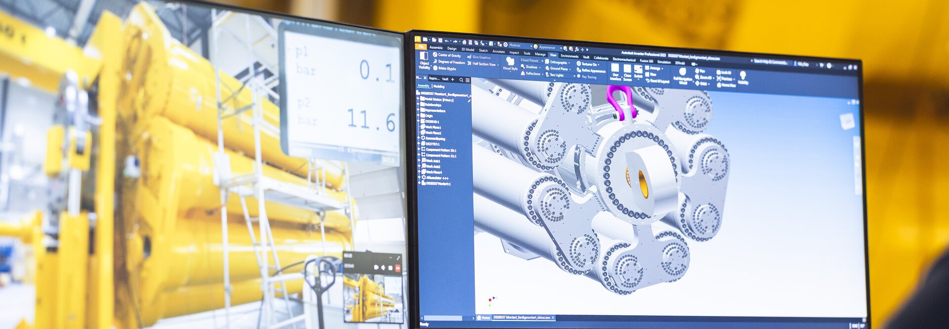 En person sitter og ser på 3D-tegning av hydraulisk demper foran demperen