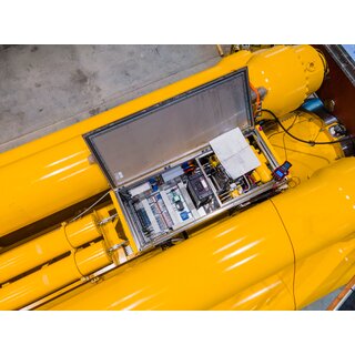 Drone image looking down at an open control cabinet on top of a hydraulic shock absorber 