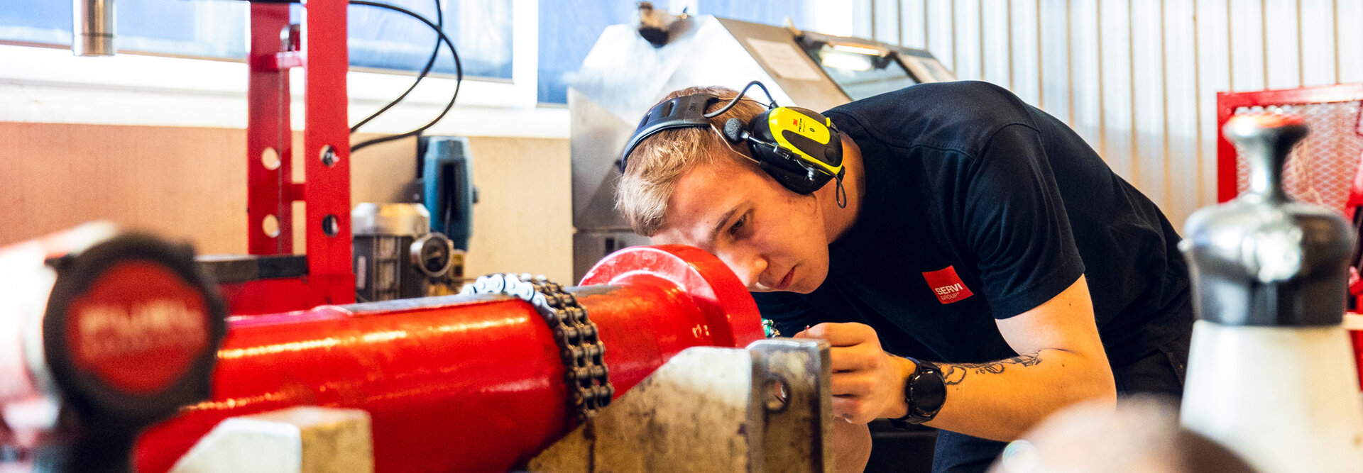 Ung serviceteknikker jobber med en rød sylinder på sylinderfabrikken i Rissa