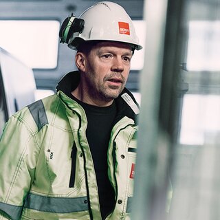 Servicemann på vei til oppdrag ved siden av servicebil