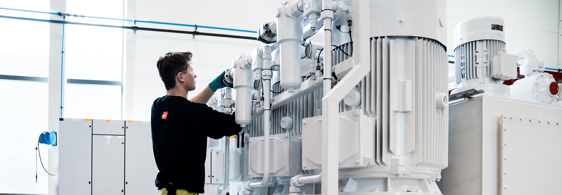 A person working on a hydraulic power unit in the workshop