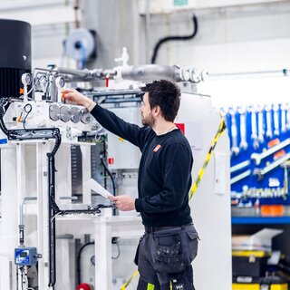En person jobber på et hvit hydraulisk aggregat