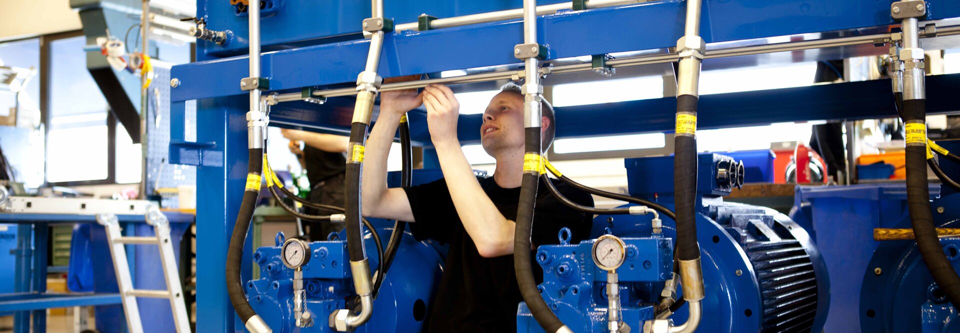 Person in workshop working on a blue hydraulic power unit