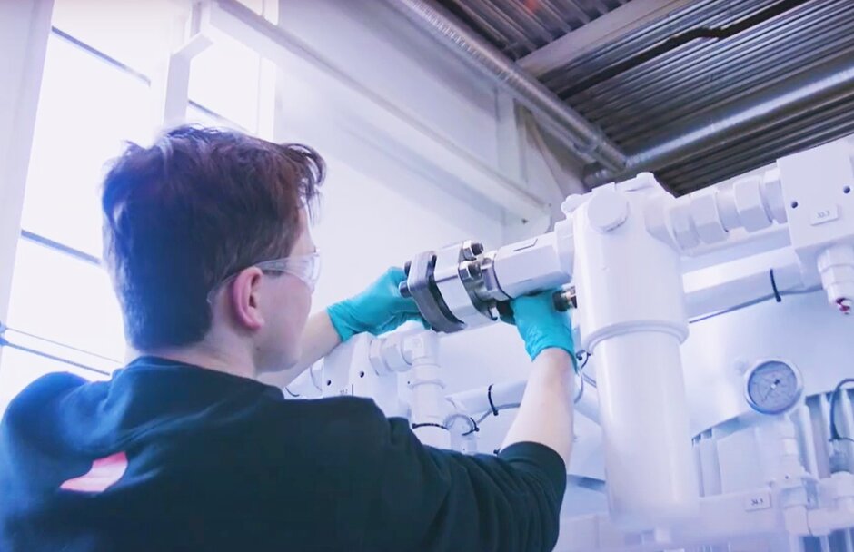 Person works on hydraulik power unit with green gloves