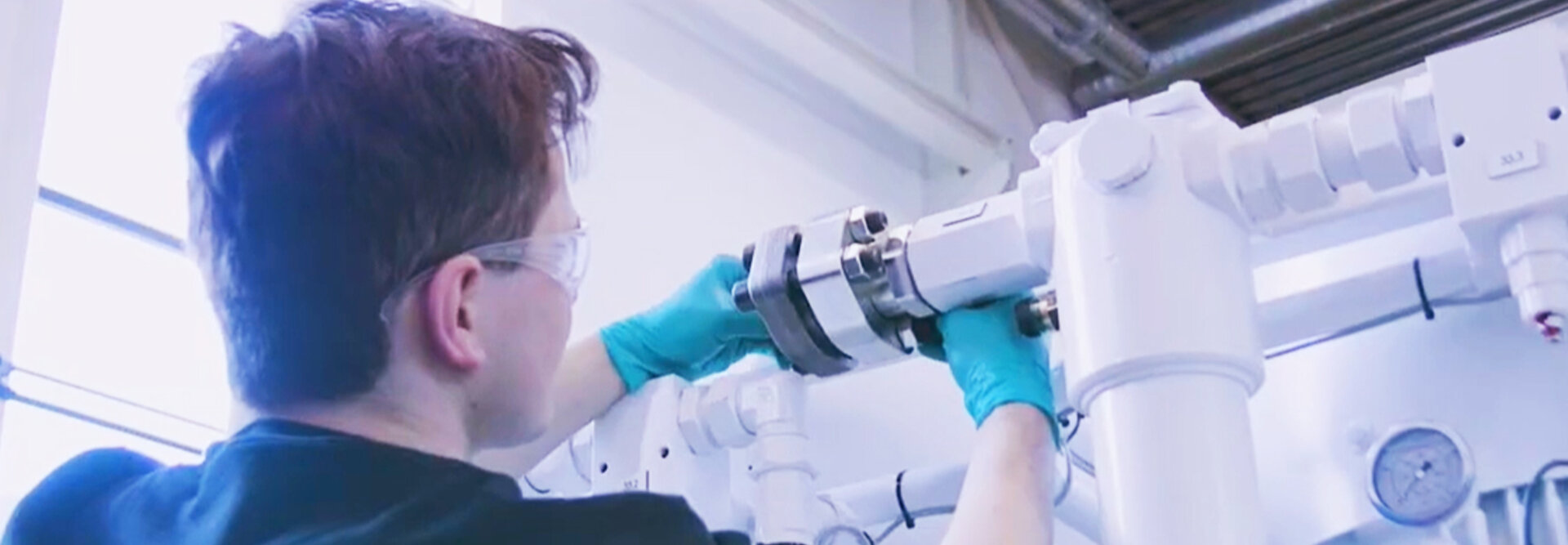 Person works on hydraulik power unit with green gloves